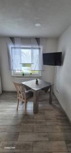 a table and a chair in a room with a window at Ilo's Zimmervermietung in Stadtallendorf