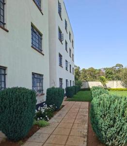 a white building with bushes in front of it at The ZEN DEN in Eldoret