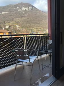 a balcony with a table and chairs and a mountain at Albergo Valle d'Oro in Albino