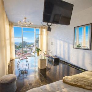 a living room with a tv and a table and chairs at Amazing View From Los Fuertes in Puebla