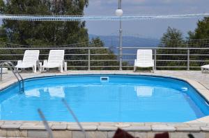 a swimming pool with two chairs at Guest House Vila Horizont in Goč