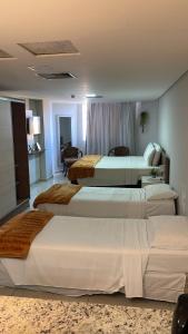 a hotel room with three beds in a room at Nobile Imperial Flat in João Pessoa