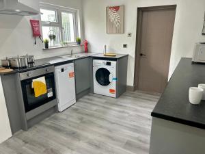 a kitchen with a washing machine and a dishwasher at S5 Private Ensuite Room for Professionals AND contractors LNG Grain digs in Gillingham +1 photo