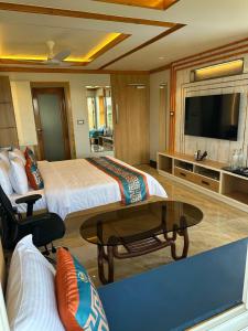a hotel room with a bed and a flat screen tv at The VP Residency Towerrs in Tiruttani