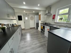 a kitchen with black counters and white cabinets and a counter top at S5 Private Ensuite Room for Professionals AND contractors LNG Grain digs in Gillingham
