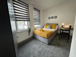 a bedroom with a bed and a desk and windows at S5 Private Ensuite Room for Professionals AND contractors LNG Grain digs in Gillingham