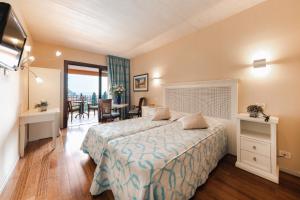 a hotel room with a bed and a dining room at Villa Madrina Lovely and Dynamic Hotel in Garda +82 photos