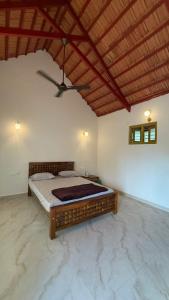 a bedroom with a large bed with a ceiling at Taniva Dani by CoffeeBeanVilla in Sakleshpur