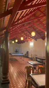 a large room with tables and chairs and wooden ceilings at Taniva Dani by CoffeeBeanVilla in Sakleshpur