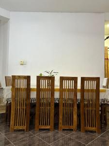 a row of wooden chairs next to a table at LOTUS HOLIDAY REST in Anuradhapura