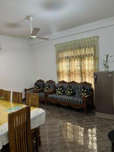 a living room with couches and a table and a refrigerator at LOTUS HOLIDAY REST in Anuradhapura