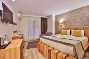 a hotel room with a large bed and a television at Livadi Jur in Akçakoca