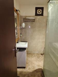 a bathroom with a sink and a clock on the wall at Hotel The Rajputana Ranthambore in Sawāi Mādhopur