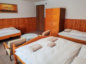 a bedroom with two beds and a table at ZorHouse Ždiar in Ždiar +3 photos