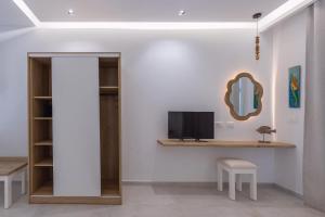 a room with a desk with a tv on a wall at Evriali Seaside Rooms in Platamonas