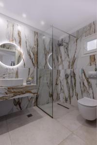 a bathroom with a shower and a sink and a toilet at Evriali Seaside Rooms in Platamonas +117 photos