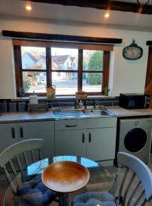 a kitchen with a table and a sink and a window at The Barn at Creech View in Wareham
