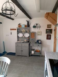 a kitchen with a counter with plates on the wall at The Barn at Creech View in Wareham +22 photos