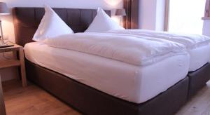 ゼーフェルト・イン・チロルにあるAppartement Seejochの大型ベッド(白いシーツ、枕付)