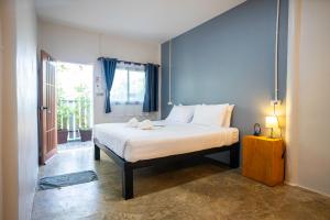 a bedroom with a white bed with a window at Fix25House Koh Kood in Ban Khlong Mat