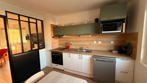 a small kitchen with a sink and a microwave at Appartement spacieux rénové, vue mer - 2 chambres in Berck-sur-Mer