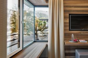 a room with a large window with a view at Stadthotel Brunner in Schladming