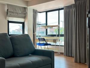 a living room with a couch and a desk at Msthouse in Ban Bang Phun
