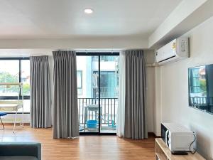a living room with a couch and a tv at Msthouse in Ban Bang Phun