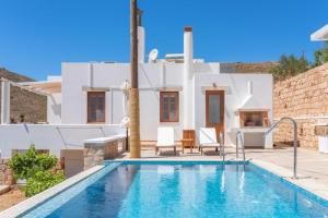 a swimming pool in front of a villa at Alykes Studios in Grikos
