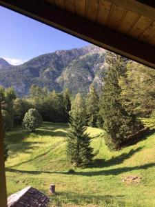 a view from a window of a field with trees and mountains at Casa PerAria in Paluzza