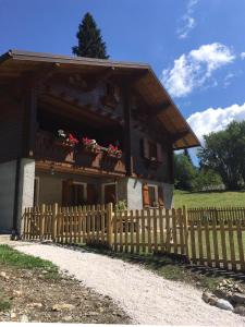 a house with a wooden fence in front of it at Casa PerAria in Paluzza +18 photos