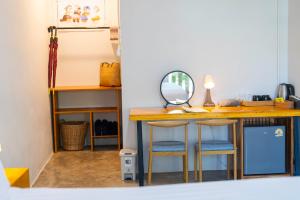 a room with a desk with two stools and a mirror at Fix25House Koh Kood in Ban Khlong Mat