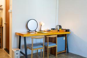 a desk with two chairs and a mirror on it at Fix25House Koh Kood in Ban Khlong Mat