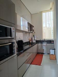 a kitchen with stainless steel appliances and a red rug at Casa Tranquila em Diamantina in Diamantina +9 photos