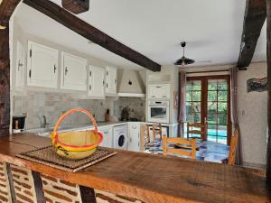 a kitchen with white cabinets and a basket on a wooden counter at Gîte de Maurin campagne in Marguestau