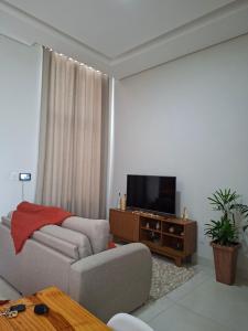 a living room with a couch and a flat screen tv at Casa Tranquila em Diamantina in Diamantina