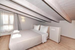 a bedroom with a large white bed and a window at Helichrysum Lofts Junior House J1 in Khokhlastí +35 photos