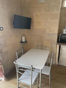a white table and chairs in front of a brick wall at Casa vacanze da Savio in Trani