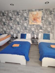 a room with two beds with blue sheets at Jolsva in Rokiškis