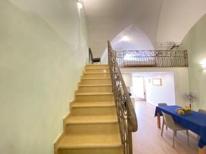 a staircase in a room with a blue table at Corso Suite Gallipoli in Gallipoli