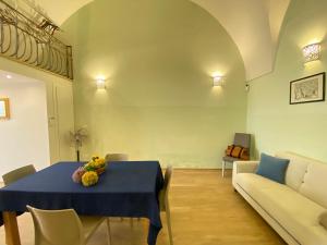 a dining room with a blue table and a couch at Corso Suite Gallipoli in Gallipoli