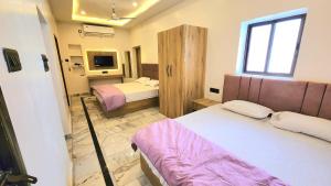 a hotel room with two beds and a window at Hotel RK Heritage in Varanasi +3 photos