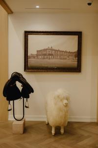 a white sheep standing under a painting on a wall at Pana Unique Semey in Semey +124 photos