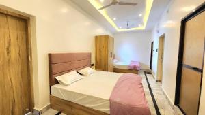 a bedroom with a large bed with a wooden headboard at Hotel RK Heritage in Varanasi