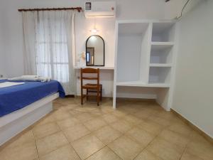 a bedroom with a bed and a desk and a mirror at Amodari studios on the beach in Plaka +64 photos