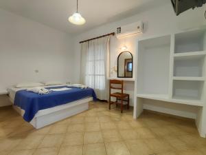 a bedroom with a bed and a table and a mirror at Amodari studios on the beach in Plaka