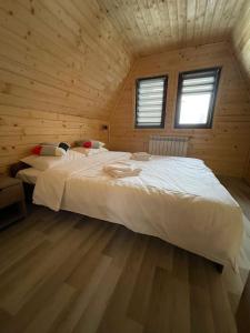 a bedroom with a large bed in a wooden cabin at Cabana De Peste Gard in Topliţa