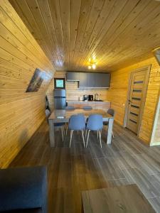 a kitchen with a table and chairs in a room at Cabana De Peste Gard in Topliţa