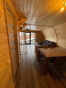 a dining room with a table and chairs at Cabana De Peste Gard in Topliţa