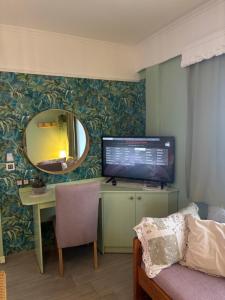 a room with a desk with a computer and a mirror at T H E BERLIN Studios and Suites in Nea Vrasna